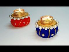 two small candles sitting next to each other on top of a white table with red and blue decorations