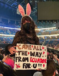 a person in bunny ears holding a sign at a sporting event with the words came all the way from evador for uu