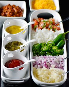 a tray filled with different types of food on top of a black table next to sauces and condiments