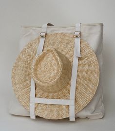 Inspired by being on holiday. Traveling with your hat has never been easier. The Augustine hat tote will be your new favorite travel accessory. Structured 18oz canvas with genuine leather trim. Exterior straps to secure your hat. A bottom strap that will keep your hat straight, even if the bag bends. Featuring 3 interior pockets, 2 open 12x18 cm, and 1 large zippered pocket. Luxury Hats, Hat Holder, Holiday Hats, Travel Tote Bag, Leather Hats, Unique Bags, Tote Bag Pattern, Carrier Bag, On Holiday