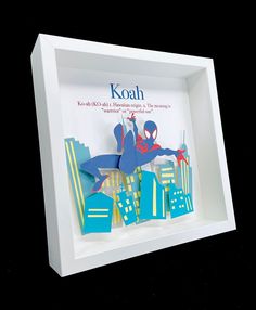 an origami spider man is in a white shadow box with the name koah on it