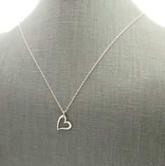 "Silver Heart Necklace | Sterling Silver Heart Charm Necklace | .925 Silver Cutout Heart Jewelry This sterling silver heart charm necklace features a solid, shiny, off-centered 925 silver heart pendant on a solid sterling silver chain. The cutout heart design has a lovely thick 3D design. The heart pendant is hung from one edge on a solid sterling silver chain (choose length at checkout). The silver heart necklace is packaged in a gift tin, ready to give as a Valentine's Day gift or other specia Heart Charm Necklace, Silver Heart Pendant, Silver Heart Necklace, Necklace Sterling Silver, Sterling Silver Heart, Heart Jewelry, Heart Design, 3d Design, Silver Heart