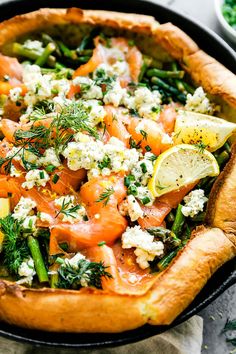 a pizza topped with lots of veggies on top of a black pie pan