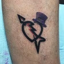 a man with a hat and lightning bolt tattoo on his leg is wearing a top hat