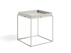 a white square side table with a metal frame on the bottom and an open drawer at the top