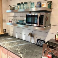 a stainless steel microwave oven sitting on top of a counter next to a toaster oven