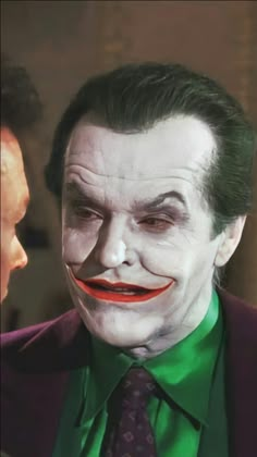 a close up of a person wearing a joker mask