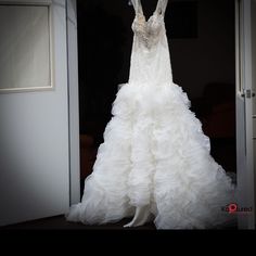 a wedding dress is displayed in front of a door