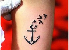 an anchor with birds flying around it on the side of a woman's arm