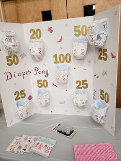 a table with several diapers on it and pink towels next to the sign that says 50