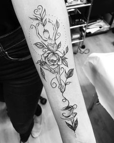 a black and white photo of a woman's arm with flowers on it