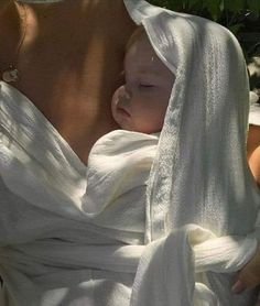 a woman holding a baby wrapped in a towel