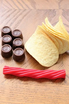 some food is laying out on a wooden table next to a red straw and chocolates