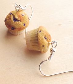 two muffins with blueberries are hanging from silver earwires