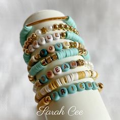 a stack of bracelets on top of a white mannequin with the word love spelled in different languages