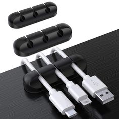 three different types of cables connected to each other on top of a wooden table with black and white accessories