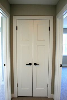 an empty room with two white doors and carpet