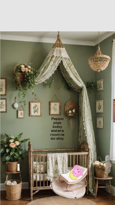 a baby's room decorated in green and white with flowers on the wall, hanging plants