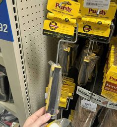 a person is holding some kind of tool in their hand and it's on the shelf