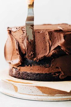 a knife is cutting into a chocolate cake