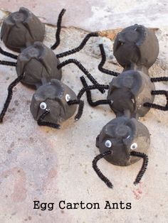 four black plastic balls with eyes and legs made to look like a spider on the ground