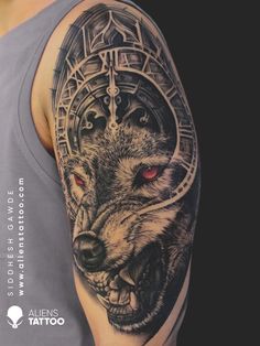 a man's arm with a wolf and clock tattoo on the left side of his arm