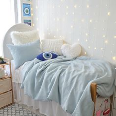 a bed with blue sheets and pillows in a room decorated for christmas or new year's eve