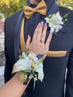 a man in a tuxedo with his hands on his lapel flower bouquet