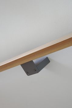 a close up of a wooden shelf with a metal object on the top and bottom