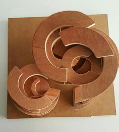 three pieces of wood sitting on top of a piece of cardboard with the shape cut out