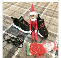 an elf is sitting on the floor next to some shoes and stringing with a toothbrush