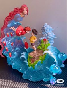 two figurines that are on top of a wave