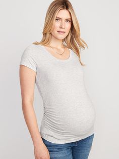 a pregnant woman in jeans and a t - shirt poses for the camera with her hands on her hips