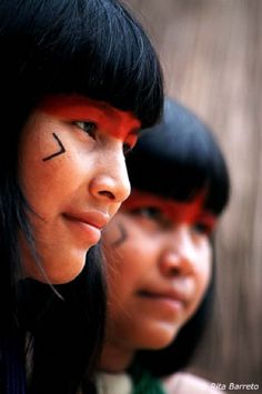 two native american girls with painted faces and arrows on their foreheads, looking at the camera