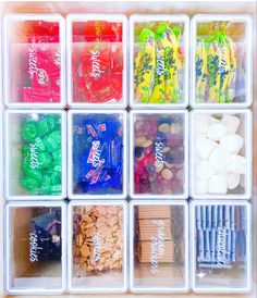 an organized drawer filled with different types of candy and candies in plastic bins