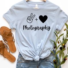 a t - shirt with the word photography on it and a pair of sandals next to it