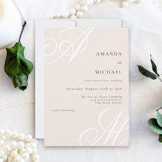 the wedding stationery is laid out next to some flowers