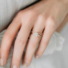 a woman's hand with a diamond ring on it