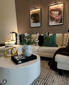 a living room filled with white furniture and lots of pillows on top of it's coffee table