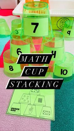 some cups and numbers are sitting on the table with green cups in front of them