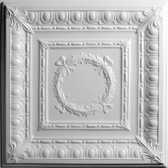 a white ceiling tile with an ornate design on the top and bottom part of it