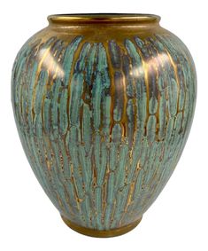 a green and gold vase sitting on top of a table