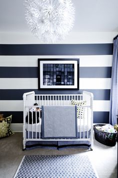 a baby's room with blue and white striped walls