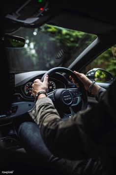 a person driving a car in the dark with their hands on the steering wheel,