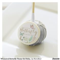 a white and gray baby shower ball with a butterfly on it's top sitting on a table