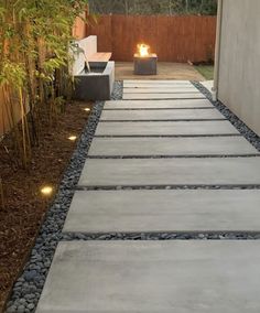 a walkway made out of concrete with lights on each side