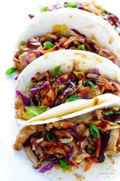 three tortillas filled with shredded meat and veggies