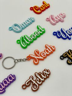 many different colored key chains with the word hello written on them in cursive writing