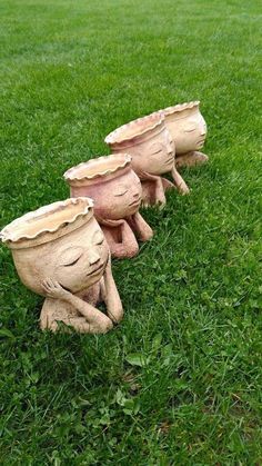 three clay pots sitting on top of green grass