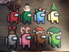 several pixel art pieces are displayed on a wooden surface, including one of them has an image of santa claus and other characters